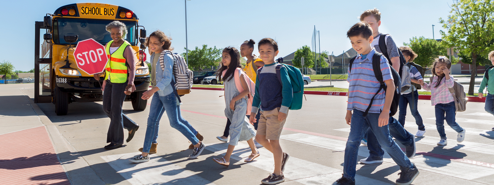 Diverse group of children cross safely to school